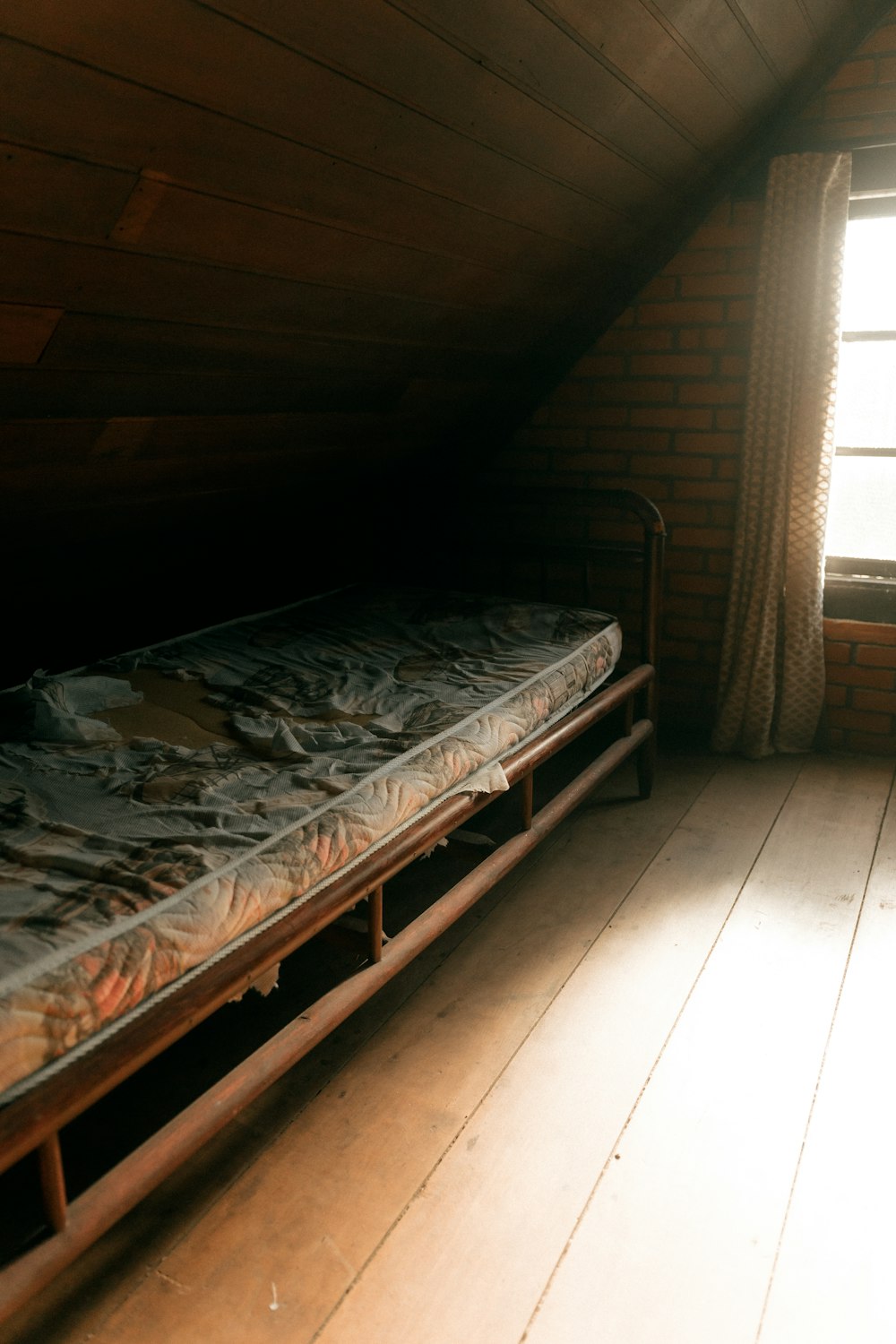 Cama antigua con colchón en un ático